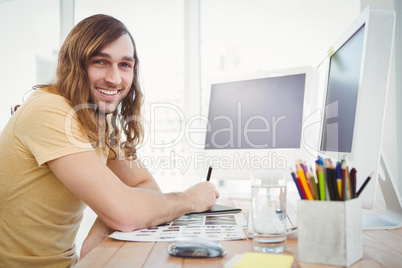 Portrait of happy hipster working at desk