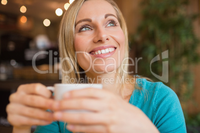 Close-up of thoughtful young woman holding coffee cup