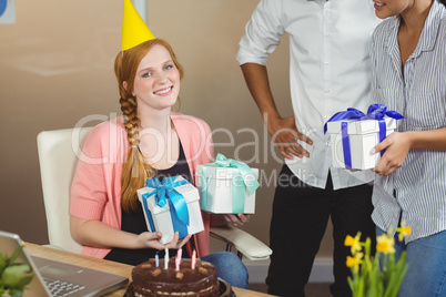 Portrait of happy businesswoman receiving birthday gifts