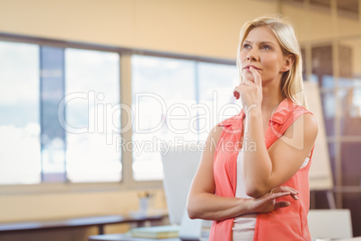 Thoughtful businesswoman with finger on lips