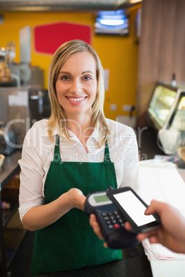 Portrait of female worker accepting payment through NFC