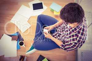 Hipster using smartphone while working in office