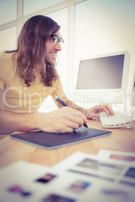 Hipster with graphics tablet typing on keyboard