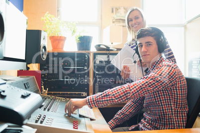 Portrait of male radio host using sound mixer