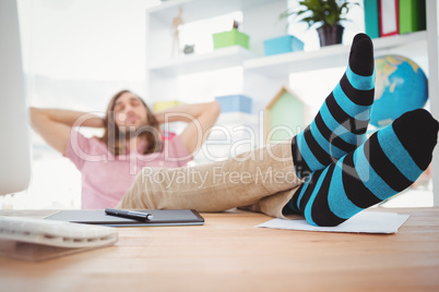 Hipster resting with legs on desk
