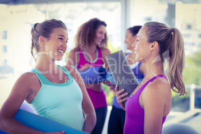Attractive women looking at each other and smiling in fitness st