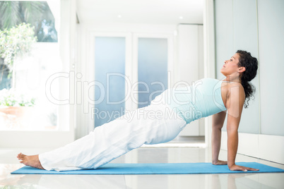 Pregnant woman exercising on mat