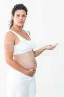 Serious pregnant woman holding pills