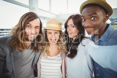 Woman taking selfie with coworkers making faces