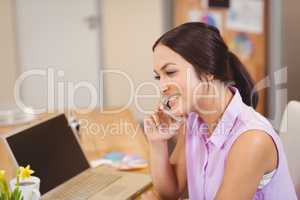 Businesswoman talking on phone at desk