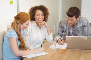 Smiling businesswoman with colleagues in meeting