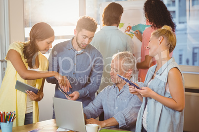 Businessman showing something to colleagues on smart phone