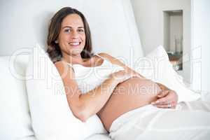 Portrait of pregnant woman on bed