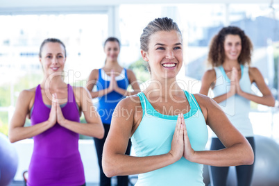 Happy women with hands together in fitness studio