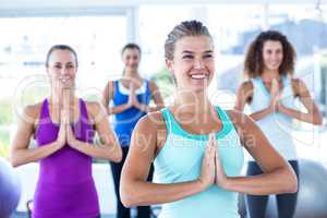 Happy women with hands together in fitness studio