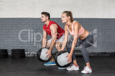 Muscular couple doing ball exercise