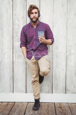 Hipster holding mobile phone listening music