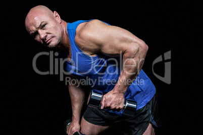 Portrait of fit man exercising with dumbbells