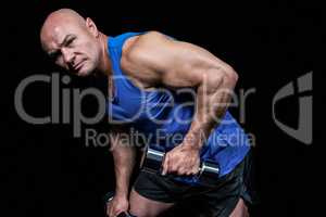 Portrait of fit man exercising with dumbbells