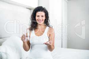 Portrait of attractive pregnant woman taking pill