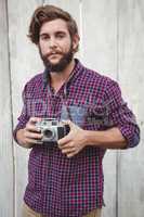 Portrait of confident hipster using camera