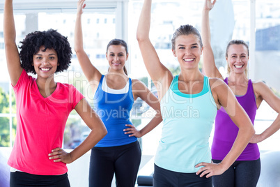 Portrait of women lifting one arm and smiling