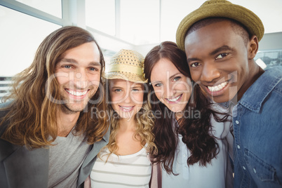 Portrait of smiling business team with arms around at office