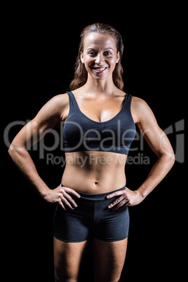 Portrait of cheerful athlete with hands on hip