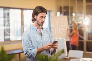 Serious businessman texting on phone