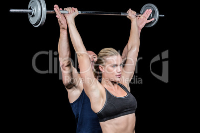 Male trainer assisting woman for lifting crossfit