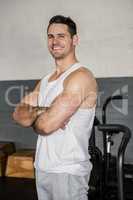 Portrait of a smiling muscular man with arms crossed