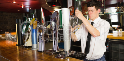 Barkeeper holding glass in front of beer dispenser