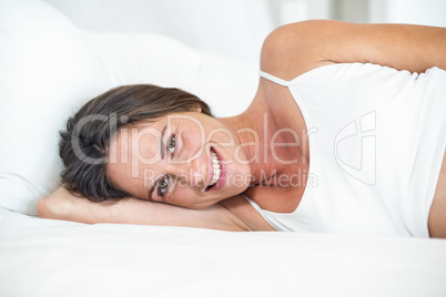 Portrait of happy woman lying on bed