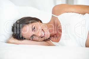 Portrait of happy woman lying on bed