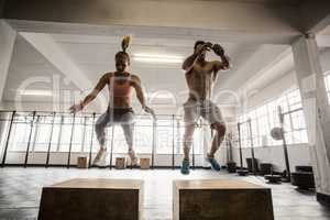 Fit couple doing set of box jumps