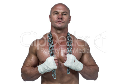 Portrait of confident bodybuilder holding chain around neck