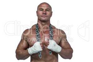 Portrait of confident bodybuilder holding chain around neck