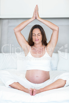 Happy woman meditating on bed