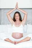 Happy woman meditating on bed