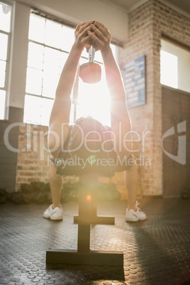 Man lifting dumbbell while lying on the bench