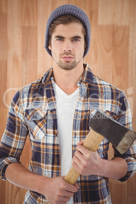 Portrait of confident hipster holding axe