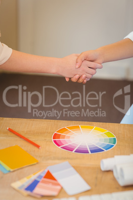 Clients shaking hands with businesswoman in office