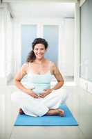 Portrait of smiling pregnant woman touching her belly