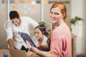 Portrait of businesswoman holding digital tablet in office