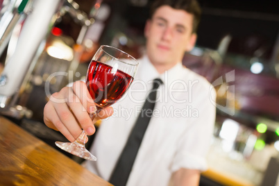 Male barkeepe serving alcohol