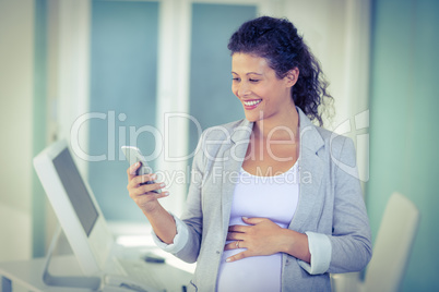 Pregnant  businesswoman using mobile phone