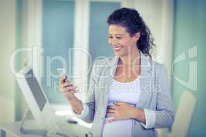 Pregnant  businesswoman using mobile phone