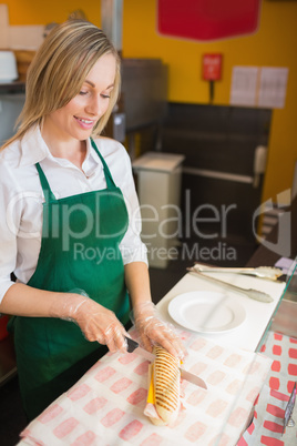 Female worker cutting sandwich