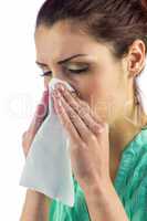 Close-up of sneezing woman with eyes closed and tissue on mouth
