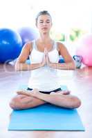 Woman doing meditation pose on yoga mat